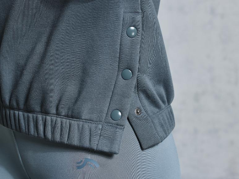 Graue Jogginghose mit Logo und ein Sweatshirt mit Knöpfen.