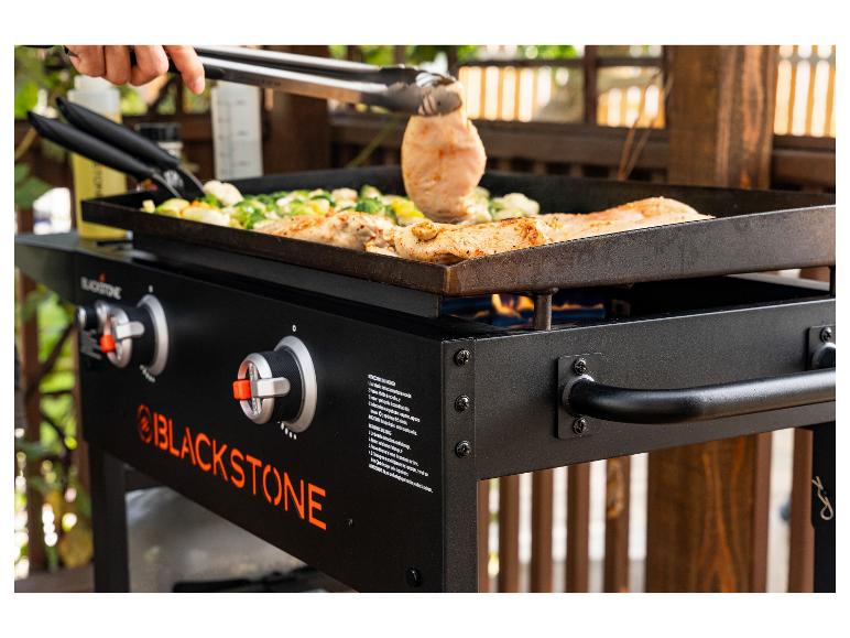 Flachgrill mit Fleisch und Gemüse beim Kochen, mit Zündanweisungen.
