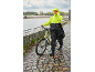 Frau in gelb-schwarzer Regenjacke geht mit ihrem Fahrrad im Regen.