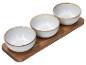 Set aus drei weißen Keramikschalen auf einem Holztablett