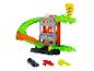Spielzeugautobahn mit grünem Alligator, Gebäude und Pizzaschild, mit drei Spielzeugautos.