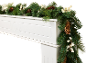 Weihnachtsgirlande mit Tannenzapfen und weißen Beeren auf einem weißen Kamin