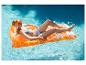 Frau im Bikini treibt auf einer orangefarbenen Luftmatratze im Pool.