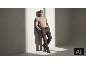 Mann in beige Pullover und brauner Hose posiert an einer Wand.