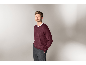 Mann in einem eleganten weinroten V-Ausschnitt-Pullover und grauer Hose.