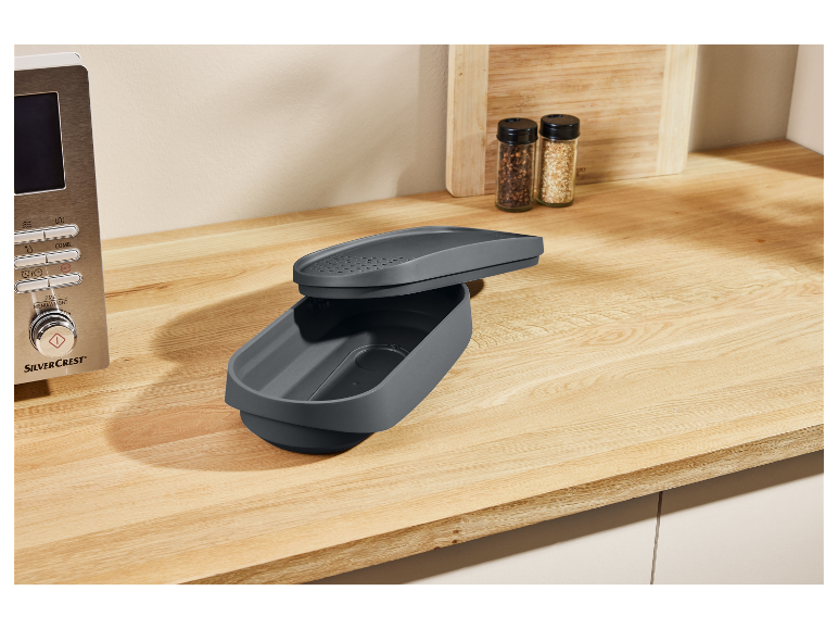 Eine graue SilverCrest-Aufbewahrungsbox auf einer Holzoberfläche.