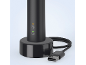 Schwarze elektrische Zahnbürste auf einer Ladestation mit USB-Kabel.