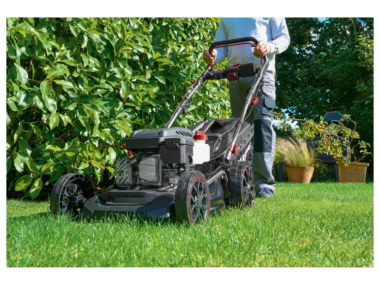 Mann mäht Rasen mit einem Parkside Rasenmäher im Garten.