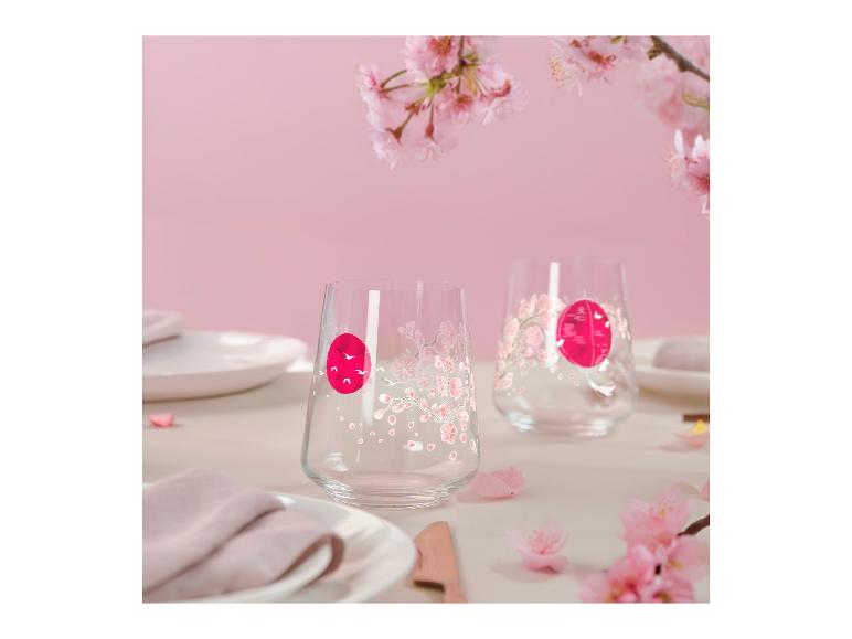 Zwei Gläser mit japanischem Kirschblütenmotiv und roter Sonne auf rosa Hintergrund.