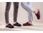Zwei Personen tragen Filzpantoffeln, einen grauen und einen bordeauxfarbenen.