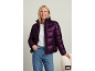 Frau in lila Pufferjacke, weißem T-Shirt und Jeans