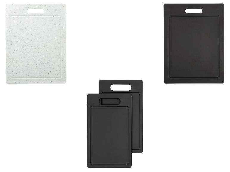 Set aus drei schwarzen und einem weißen Schneidebrett.