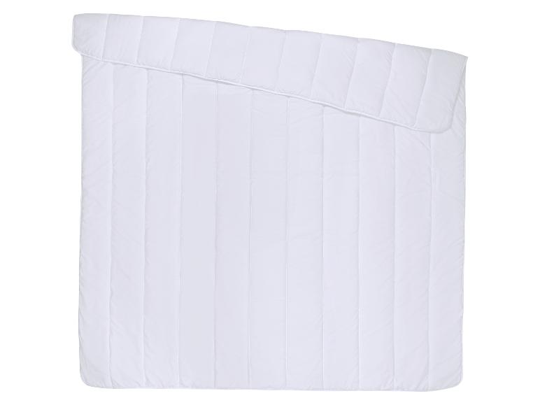 Weiße gesteppte Bettdecke mit vertikalen Nähten, in der oberen Ecke gefaltet.