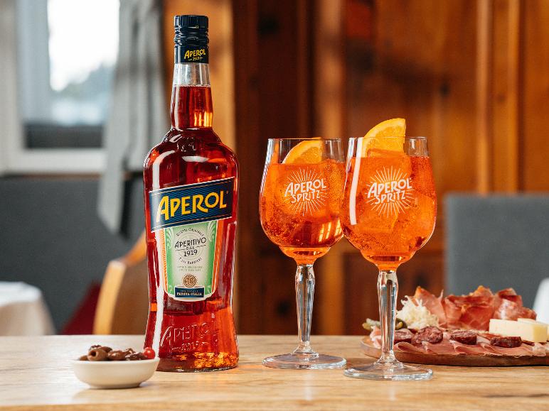 Eine Flasche Orangenaperitif und zwei Gläser Spritz-Cocktails mit Orangenscheiben.