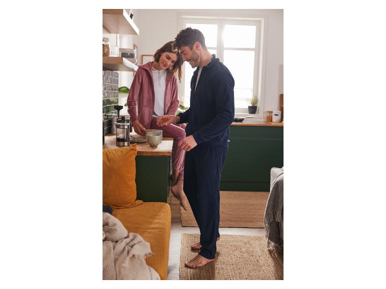 Ein Mann und eine Frau in Loungewear in einer Küche.