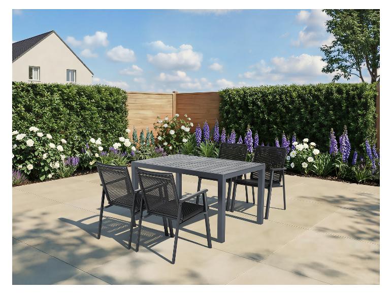 Gartensitzgruppe mit grauem Lamellentisch und vier Stühlen auf einer Terrasse, umgeben von üppigem Grün und Blumen.