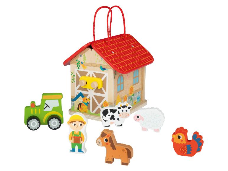 Holzbauernhof mit Traktor, Tieren und Figuren.