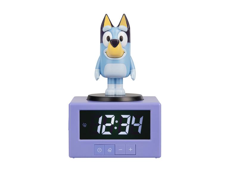 Wecker mit blauem Hundefigur und digitaler Anzeige, die 12:34 zeigt.