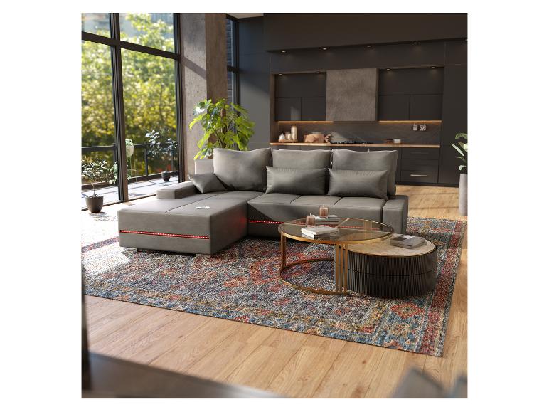 Ein graues Ecksofa mit LED-Beleuchtung, ein Glas-Couchtisch und ein Teppich in einem modernen Wohnzimmer.