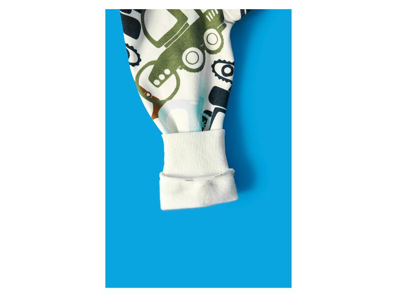 Kinderblusenärmel mit Fahrzeugaufdruck auf blauem Hintergrund.