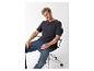 Mann in dunklem T-Shirt mit Text und Jeans, auf einem Bürostuhl sitzend.