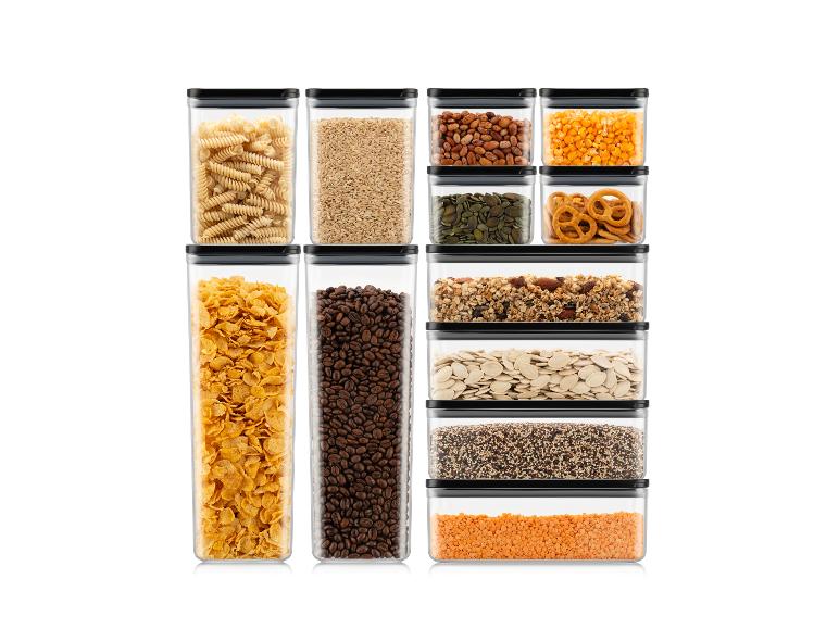 Verschiedene Lebensmittel in transparenten Behältern, darunter Nudeln, Getreide und Nüsse.