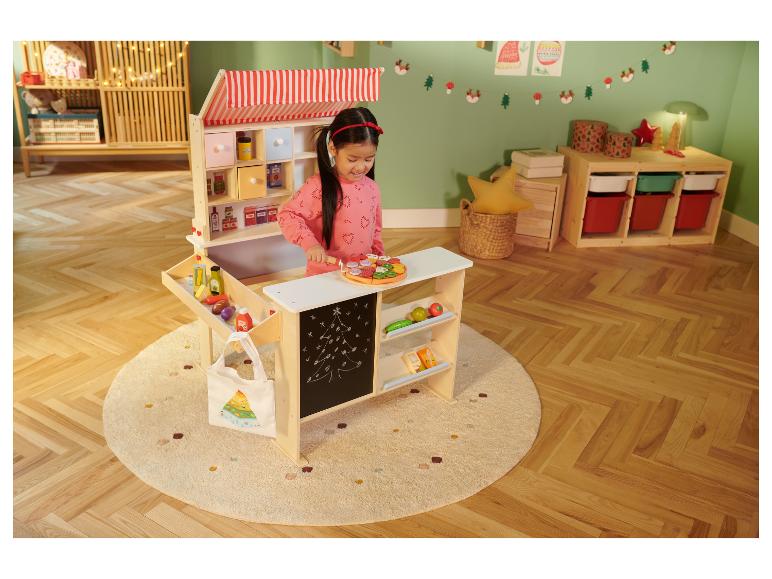 Ein Mädchen spielt mit dem LUPILU Holz-Lebensmittel-Set an einem Spielzeug-Marktstand.