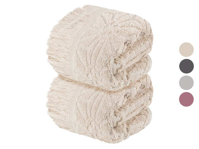 Zwei gefaltete Handtücher mit Fransen.