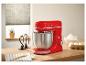 Rote Küchenmaschine mit Schüssel und Rührbesen auf einer Holztheke.