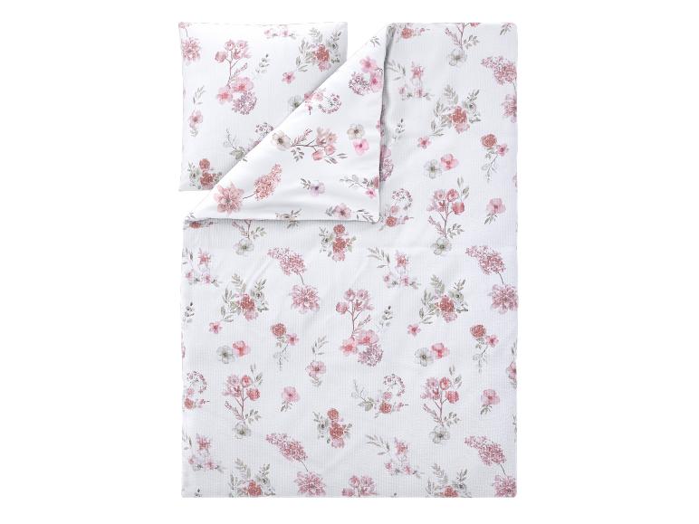 Bettwäsche-Set mit rosa Blumenmuster auf weißem Hintergrund.