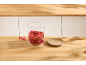 Vorratsglas mit getrockneten Erdbeeren und Holzdeckel auf einer Arbeitsplatte.