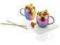 Zwei regenbogenfarbene Moscow Mule Becher mit Eis, Limette und Himbeeren, zwei Metallstrohhalme.