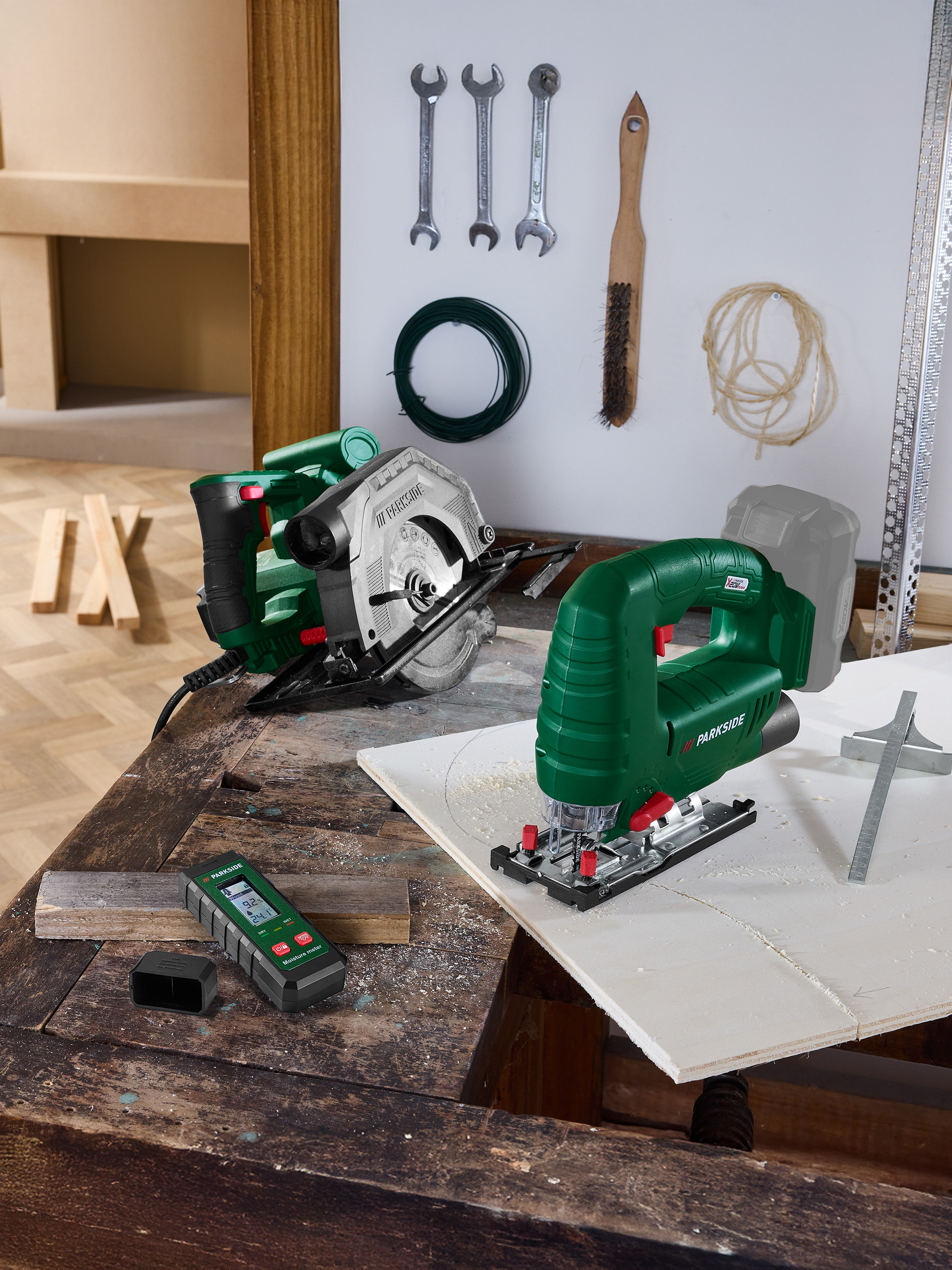 Werkzeuge auf einer Werkbank: Kreissäge, Stichsäge und Feuchtigkeitsmesser.