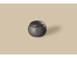 Kugelförmige Urne aus dunklem Metall mit Deckel, auf beigem Hintergrund.