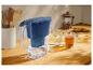 Wasserfilterkanne mit Gläsern Zitronenwasser und Tee auf einer Holztheke.