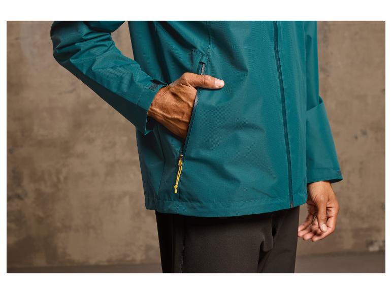 Ein Mann trägt eine dunkelgrüne Jacke mit einem gelben Reißverschluss.