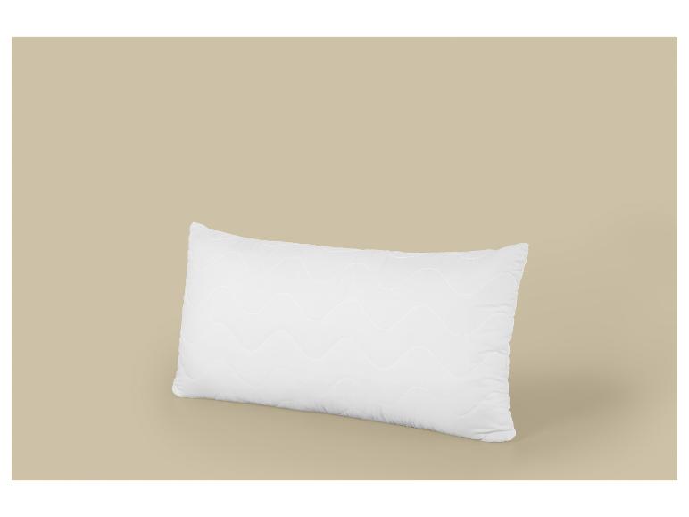 Weißes rechteckiges Kissen mit Wellenmuster auf beigem Hintergrund