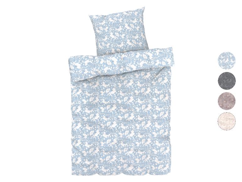 Hellblaue Bettwäsche mit weißem Blumenmuster.