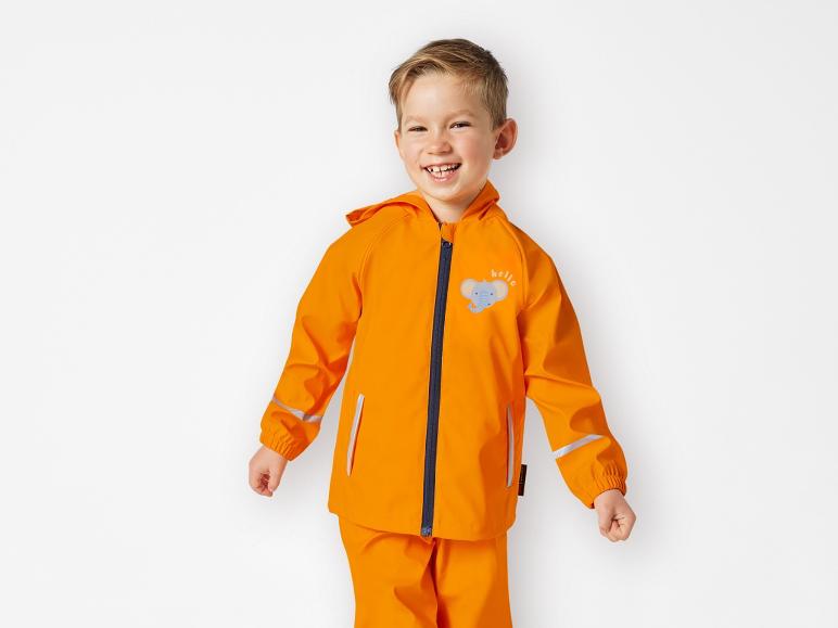 Ein Junge trägt einen orangenen Regenmantel mit einem Elefanten drauf.