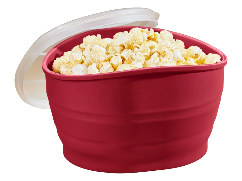 Rote zusammenklappbare Silikon-Schüssel mit Popcorn.