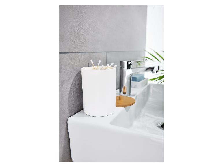 Ein weißer Badezimmerorganizer mit Wattestäbchen auf einem Waschbecken.