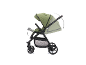 Grüner Kinderwagen mit verstellbarem Griff und Sitz, in Bewegung dargestellt