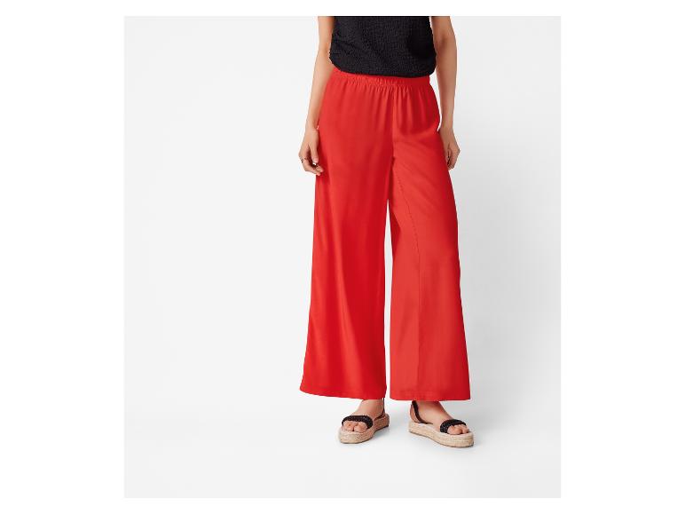 Rote weite Hose und flache Sandalen: sommerliche Damenmode.