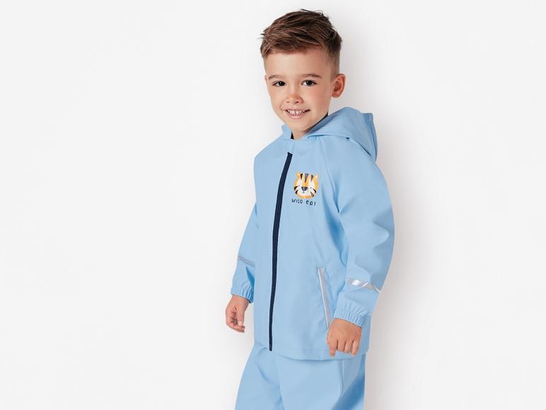 Ein Junge trägt einen blauen Regenmantel mit Tiger-Print.