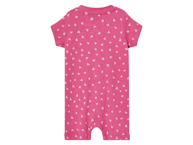Ein rosafarbener Strampler mit weißen Herzchen-Muster.