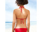 Eine Frau trägt einen roten Bikini am Strand.