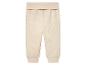 Beige Baby-Jogginghose aus weichem Stoff.