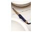 Remington Lockenstab in Gold und Dunkelblau auf Marmor.