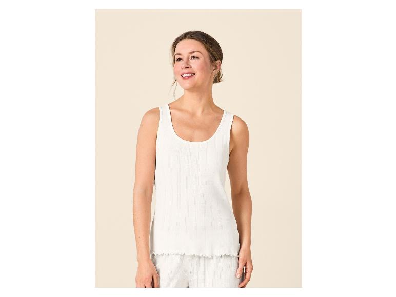 Frau in weißem Ripp-Top und gestreiften Shorts, lächelnd