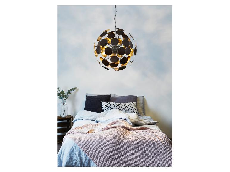 Schlafzimmer mit modernem kugelförmigem Kronleuchter, hellblauer Bettwäsche und einer rosa Strickdecke.